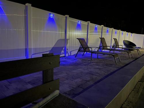 a row of chairs sitting next to a wall with blue lights at Pool Beach House in New Port Richey