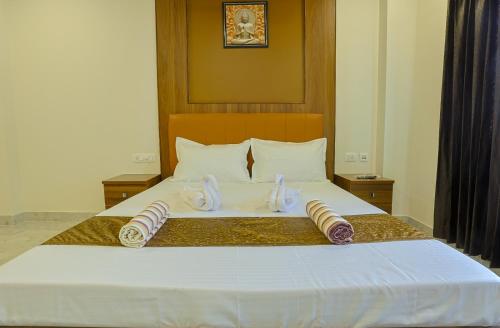 a bedroom with a bed with two slippers on it at Kayal Plaza in Coimbatore