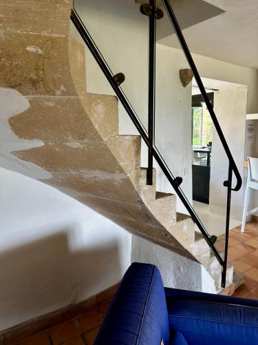 a staircase in a living room with a blue couch at Le Clos du Vialle in Grillon