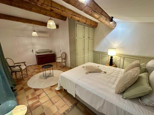 a bedroom with a bed and a room with a piano at Le Clos du Vialle in Grillon