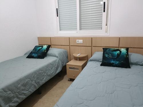 a room with two beds and a window at ACV - Torremar-2ª linea planta 8 norte in El Borseral