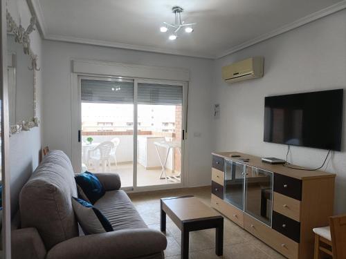 a living room with a couch and a flat screen tv at ACV - Torremar-2ª linea planta 8 norte in El Borseral