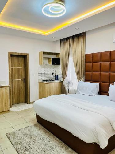 a bedroom with a large bed and a kitchen at Diaggello Homex Apartment in Lekki