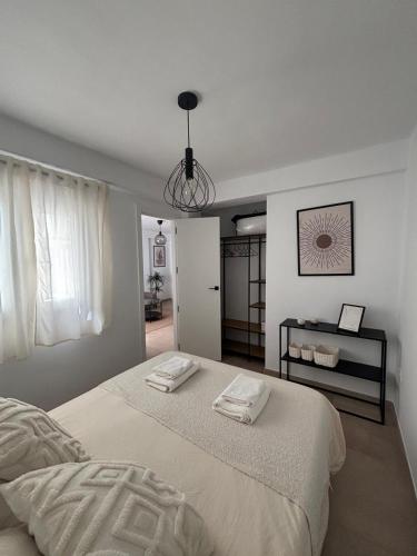 a bedroom with a bed with two towels on it at Apartamentos RoMar Campillos in Campillos