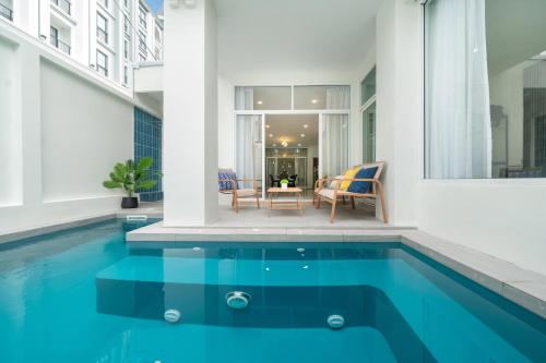 a house with a swimming pool with a table and chairs at 7BR Patong pool villa by Mp property in Patong Beach