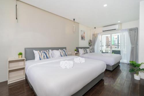 two beds in a room with white walls at 7BR Patong pool villa by Mp property in Patong Beach