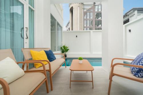 a balcony with chairs and a table and a pool at 7BR Patong pool villa by Mp property in Patong Beach