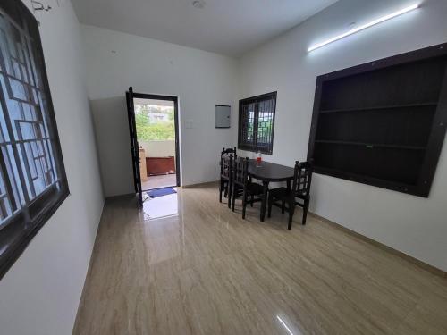 une salle à manger avec une table et des chaises dans une pièce dans l'établissement Serene Steps, à Coimbatore