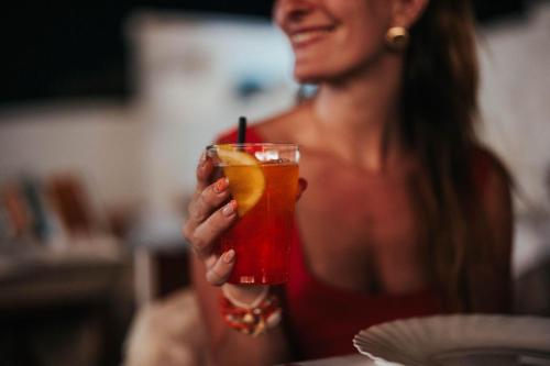 a woman is holding a drink in her hand at Luxery Resort Triglie in Crispiano