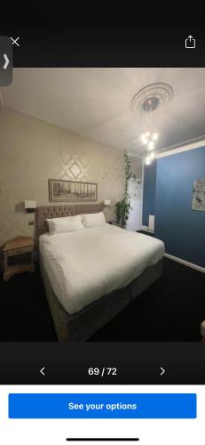 a bedroom with a large white bed with a blue wall at The Montana in Torquay