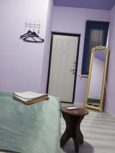 a room with a bed and a mirror and a table at Asian Guest House in Bishkek