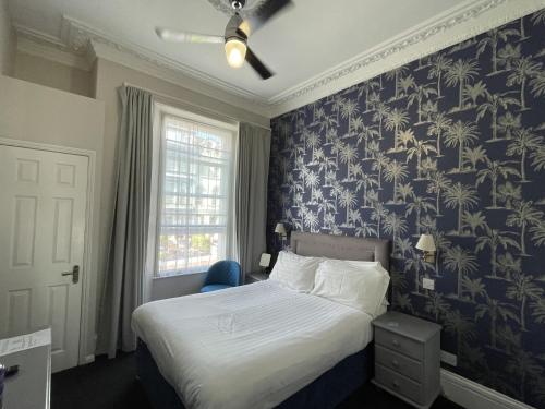 a bedroom with a bed with a blue and white wallpaper at The Montana in Torquay