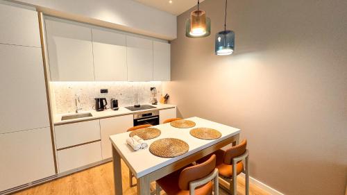 a kitchen with a white table and chairs in a room at Qumi Porto Suites in Tivat