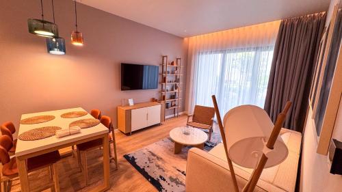a living room with a table and a dining room at Qumi Porto Suites in Tivat