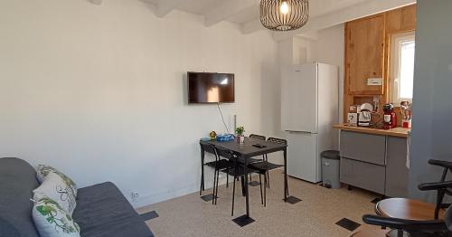eine kleine Küche mit Tisch und Kühlschrank in der Unterkunft La Pivoine in Trouville-sur-Mer