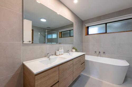 a bathroom with a sink and a tub and a mirror at Elegant Country Escape in Horsham