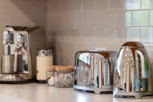 a kitchen counter with several toasters on a counter top at Elegant Country Escape in Horsham