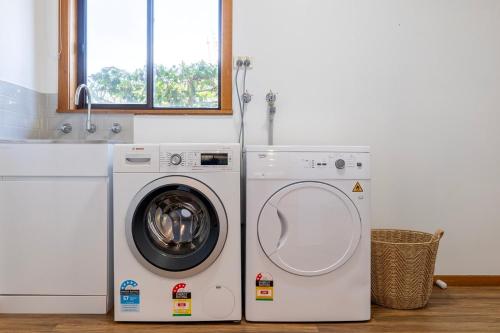 a washing machine and a dryer in a room at Elegant Country Escape in Horsham