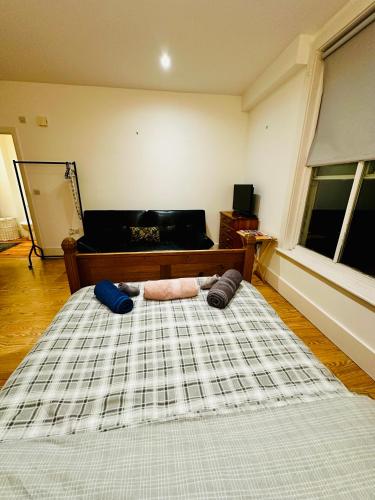 a bedroom with a large bed and a piano at Aspect apartments in Chesham
