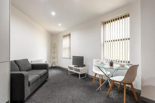 ein Wohnzimmer mit Couch und Tisch in der Unterkunft Modern & Stylish 1 Bed Budget Apartment in Central Halifax in Halifax