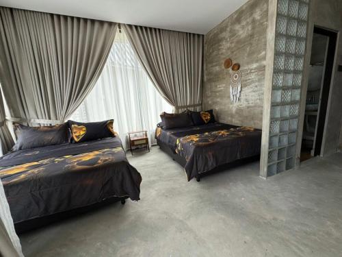 a bedroom with two beds and a large window at Villa D La Sa Pantai Penarik in Penarek