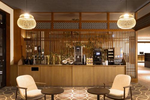 a lobby with a bar with two chairs and tables at TAOYA Nachikatsuura in Nachikatsuura