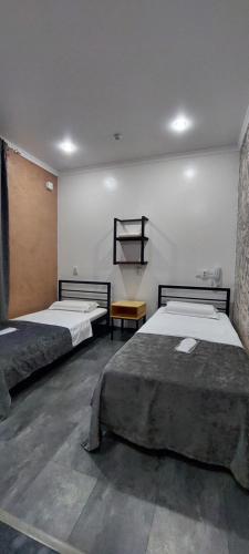 a bedroom with two beds and a table at EVFRAT-Q in Taraz
