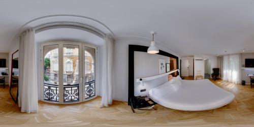 a bedroom with a large white bed and a large window at SH Ingles Boutique Hotel in Valencia