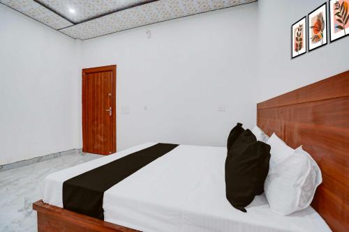 a bedroom with a bed with a wooden headboard at Collection O Sikandra Near Akbar Tomb in Agra
