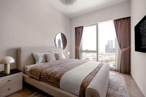 a bedroom with a large bed and a large window at Burj Khalifa View Apartment in Dubai