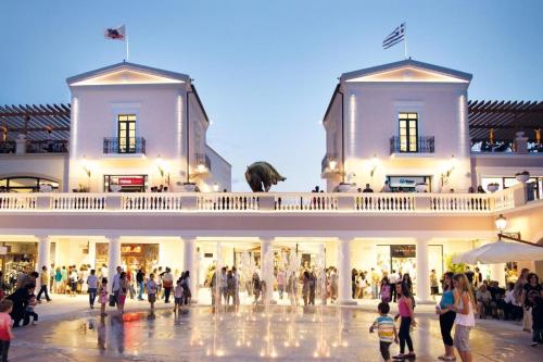 a group of people walking in front of a building at Demi's Apartments Near Athen's Airport in Artemida