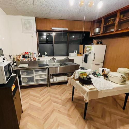 a large kitchen with a table and a refrigerator at Mahiru no Tsuki - Vacation STAY 15230v in Akasaki