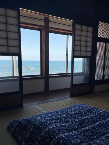 a bedroom with a bed with a view of the ocean at Mahiru no Tsuki - Vacation STAY 15230v in Akasaki