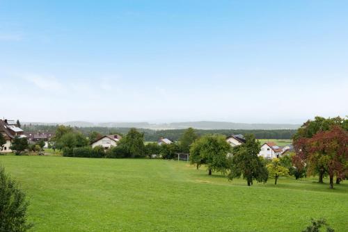a field of green grass with houses in the background at Pension Ferienwohnung Baarblick in Donaueschingen