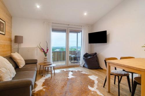 a living room with a couch and a table at Pension Ferienwohnung Baarblick in Donaueschingen