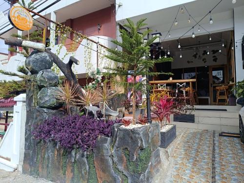 a flower garden in front of a store at D'Hills Hotel in Bukittinggi