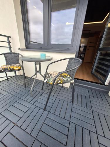 a patio with two chairs and a table and a window at Black onyx in Płock