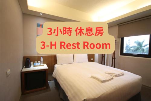 a bedroom with a bed and a sign that reads rest room at Meci Hotel in Hualien City
