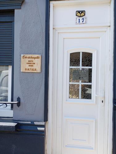 a white door of a house with a sign on it at Écrin de tranquillité in Rosières-en-Santerre