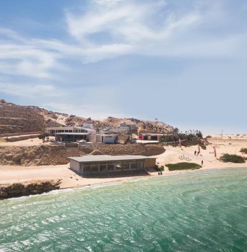 a building on a beach next to a body of water at New Spirit Dakhla in Dakhla
