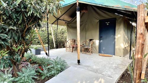 a tent with a blue door and a chair in it at Uyoga House in Arusha