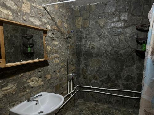 a stone bathroom with a sink and a mirror at Foleja e Shqiponjave in Tetovo