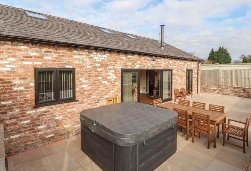 a patio with a table and chairs and a brick building at The Parlour in Helsby