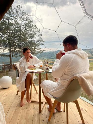 a man and woman in white sitting at a table at Bubble Room Experience in Casteldelci