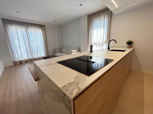 cocina con encimera de mármol y sala de estar. en Luxury Apartament Free Parking, en Tomares