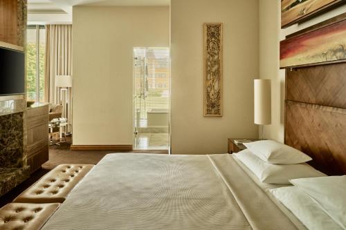 a bedroom with a large bed and a fireplace at Falkensteiner Schlosshotel Velden – The Leading Hotels of the World in Velden am Wörthersee