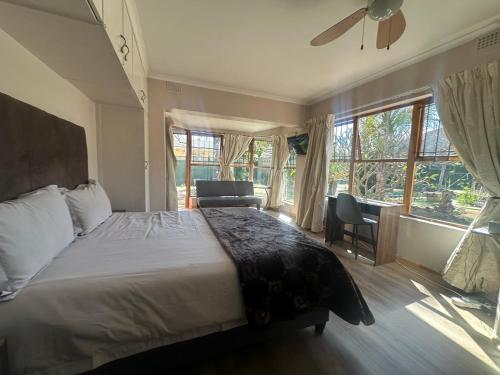 a bedroom with a bed and a large window at Suite Dreams Garden Dream Cottage in Panorama