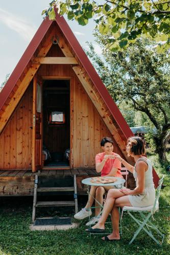 two women sitting at a table in front of a cabin at DS Camping in Grgar