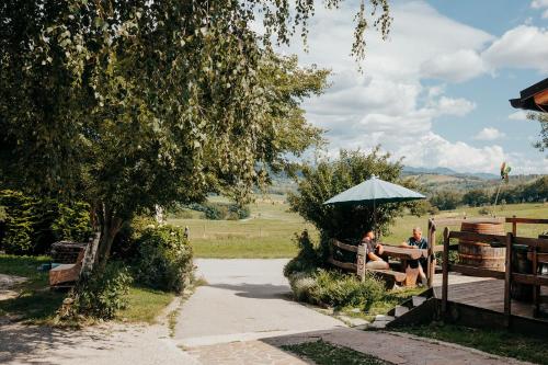 two people sitting on a bench under an umbrella at DS Camping in Grgar