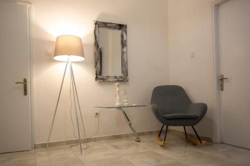 a room with a chair and a table and a mirror at Zoufi Cozy Living in Patra